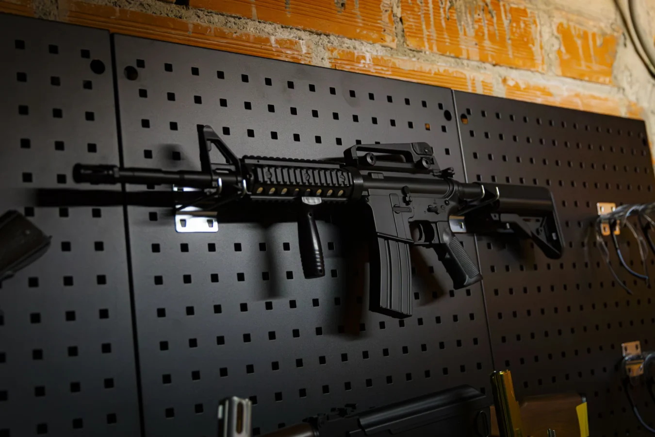 Arme La Traction Arme accrochée au mur dans le stand de tir de l’escape game de nuit Pactole avant l’Aube à Toulouse, univers mafia immersif.