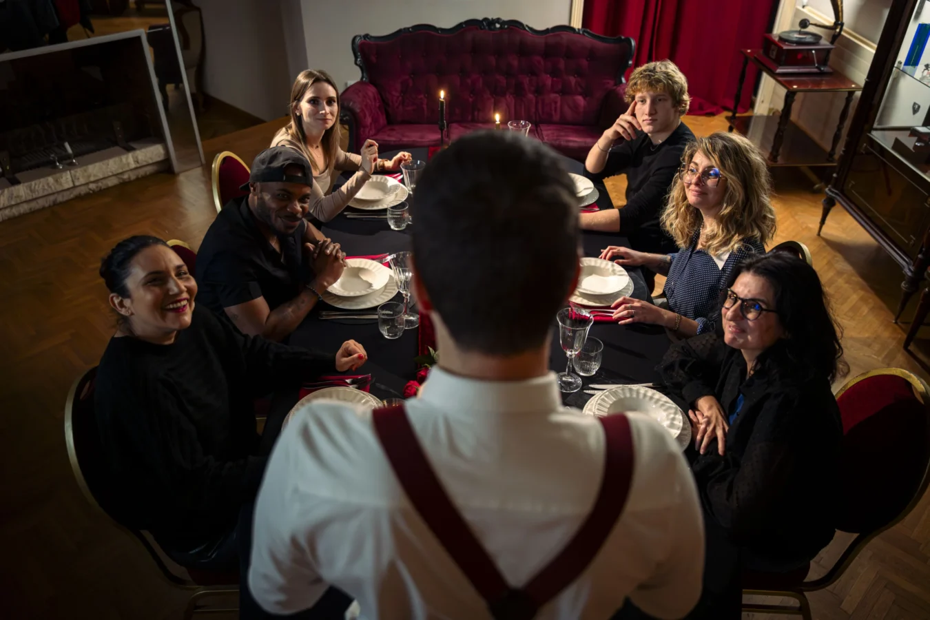 La Table du Parrain Joueurs à table pendant le repas immersif, vus depuis le dos de Pablo dans l’escape game de nuit Pactole avant l’Aube à Portet-sur-Garonne près de Toulouse.